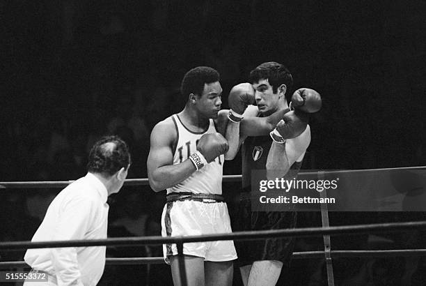 Heavyweight George Foreman, , fires a right and a left at Italy's Georgie Bambini, his own left and Bambini's own right--during Olympic bout. Foreman...