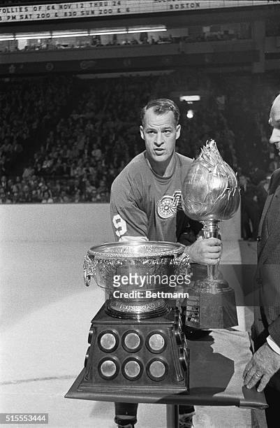 Detroit Red Wings' Gordie Howe has a big night right at the start of the hockey season in Detroit October 10th. He holds the Hart Trophy and looks at...
