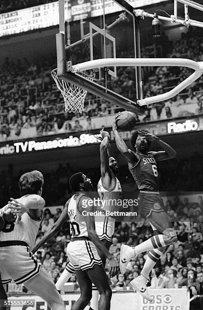 Julius Erving of the Philadelphia 76ers' grabs a rebound away from the Celtics' Cedric Maxwell and Marvin Barnes during 2nd quarter action at Boston...