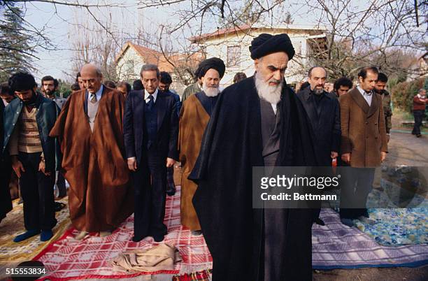 Ayatollah Ruhollah Khomeini, and members of his suite, seen during 12/7 prayer in his villa garden. Khomeini said "The Shah's train ride is coming to...