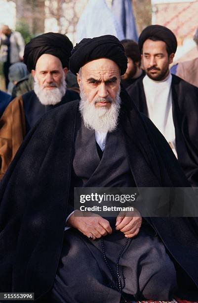 Ayatollah Ruhollah Khomeini, and members of his suite, seen during 12/7 prayer in his villa garden. Khomeini said "The Shah's train ride is coming to...