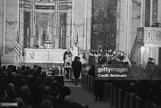 Mrs. Jacqueline Kennedy and Attorney General Robert F. Kennedy approach the altar rail to receive Communion from Richard Cardinal Cushing of Boston...