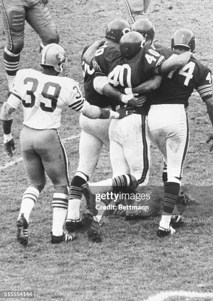 Gale Sayers, star Halfback of the Chicago Bears , is helped off of the field by teammates , Mike Pyle and Gary Lyle , after he was injured in a game...