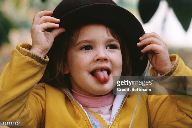 Hollywood, California: Into her own world of make believe, Drew Barrymore imagines she's a grownup as she tries on one of her mother's hats recently.