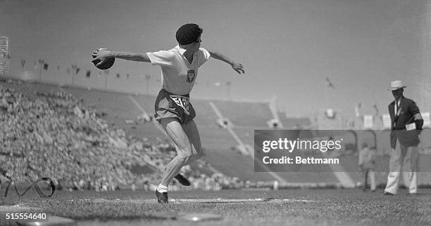 Her leg muscles standing out like steel cables, Stella Walsh, representing Poland, tightens up to heave the discus during the event in the Los...
