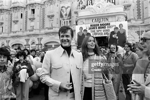 British actor Roger Moore and US actress Barbara Bach pose outside the Carlton Hotel for the presentation of the film "The spy who loved me" during...