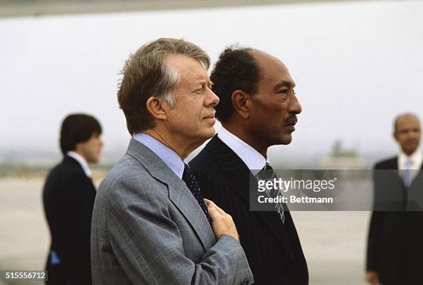 Cairo, Egypt: President Carter and Egyptian president Anwar Sadat listen to the national anthems during arrival ceremonies at Cairo Airport.