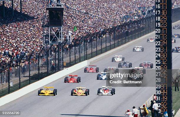 Rick Mears , who won the pole position, leads field at the start of the Indianapolis 500, which he won. Front row cars are Unser , Sneva , Mears .