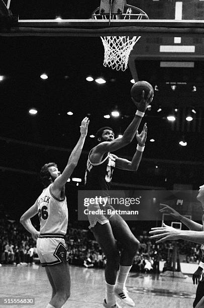 Los Angeles Center Kareem Abdul-Jabbar tosses in one of his patented sky hooks over a grounded Chicago Bull. Earvin "Magic" Johnson watches his...