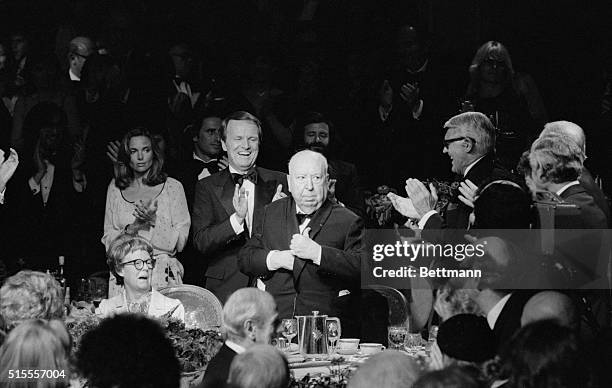 Alfred Hitchcock kiddingly puts his American Film Institute award under his coat after the 79-year-old director was honored with the Life Achievement...