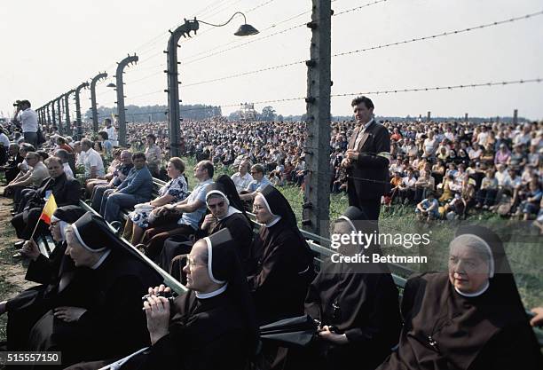 Oswiecim, Poland- A large crowd, divided by a barbed wire fence, at the Brzezinka concentration camp, listen to a mass by Pope John Paul II and...