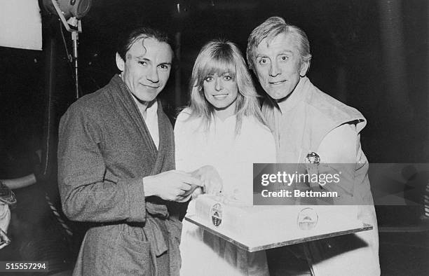 Farrah Fawcett-Majors is presented with a cake, by co-stars Kirk Douglas and Harvey Keitel on set of new science fiction thriller "Saturn 3" at the...