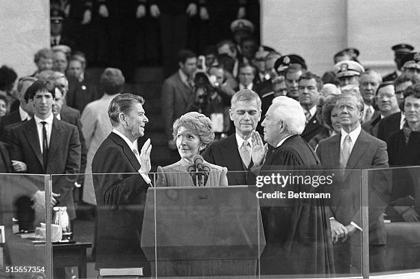 Washington, D.C.- President Reagan is sworn in at the Capitol. Left to right, are: Reagan's son, Ron; Reagan; Nancy Reagan; Senator Mark Hatfield;...