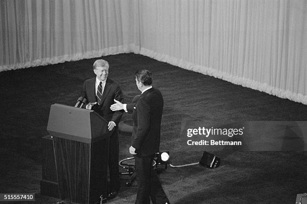 President Jimmy Carter and his Republican challenger, Ronald Reagan, shake hands as they greet one another before their debate on the stage of the...