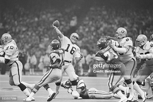 New Orleans: Oaklands' Jim Plunkett flips a short pass downfield, incomplete, as the Eagles' Randy Logan and Ken Clarke put pressure on him during...