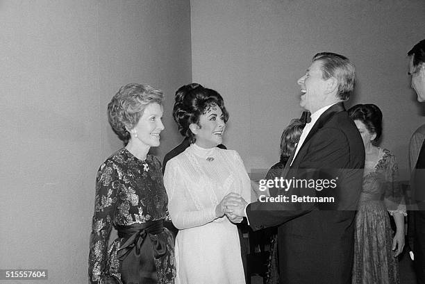 Washington: President Reagan and Mrs. Reagan greet actress Elizabeth Taylor , after her opening night at the Kennedy Center 3/19, in The Little Foxes.