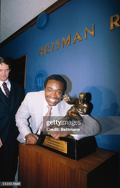 New York: Running back, George Rogers, of South Carolina hugs the Heismann Trophy presented him, December 21. The trophy, college football's most...