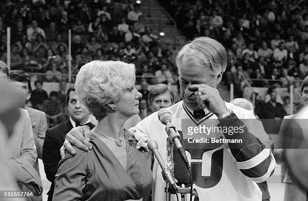 Hockey great Gordie Howe, with his arm around his wife, Colleen, wipes away a tear as he thanks fans during pre-game ceremony in which his jersey,...