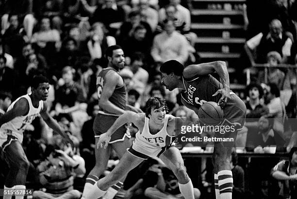 New Jersey's Mike O'Koren makes a wipe swipe at the ball and knocks it away from the hands of Philadelphia's Julius Erving under the 76ers' basket...