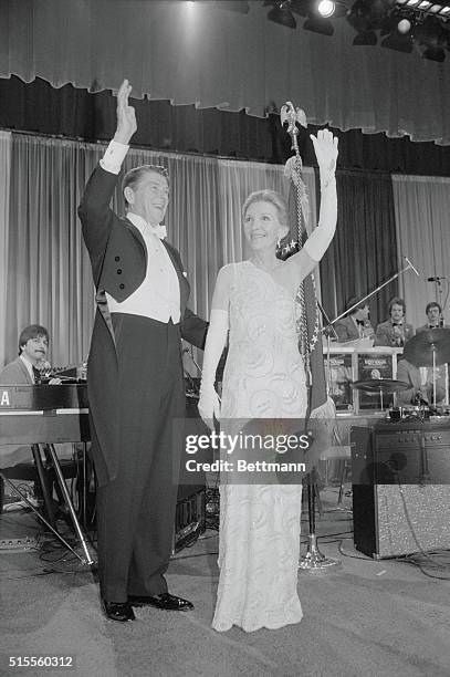 Washington, D.C.: All dressed in their finery, President and Mrs. Ronald Reagan wave to guests at the inaugural ball being held in their honor at the...