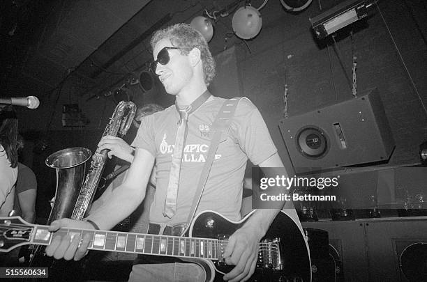 Wimbledon champion John McEnroe plays guitar as he joins a member of the Jim McMullian band to entertain at a disco party at Xenon here July 11 for...
