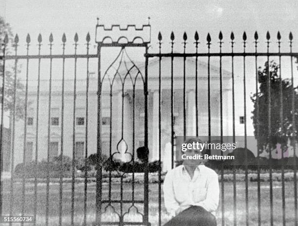 Washington, D.C.: This photo acquired by UPI shows John Hinckley Jr., as he sits on fence wall in front of the White House. Hinckley is accused as...