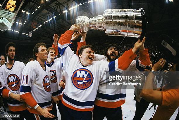 Uniondale, New York: Islands raise Stanley Cup, May 21, after defeating North Stars, 5-1, in fifth game. Anders Kallur and John Tonelli of Islanders...