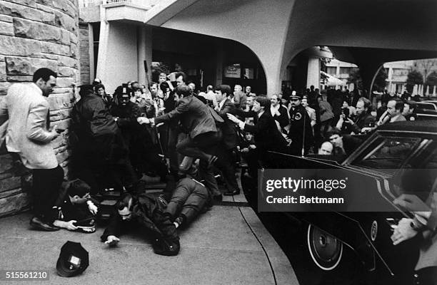 Secret service agents rush an assailant who fired six shots at President Reagan as he was leaving the Washington Hilton. This photo, released by the...