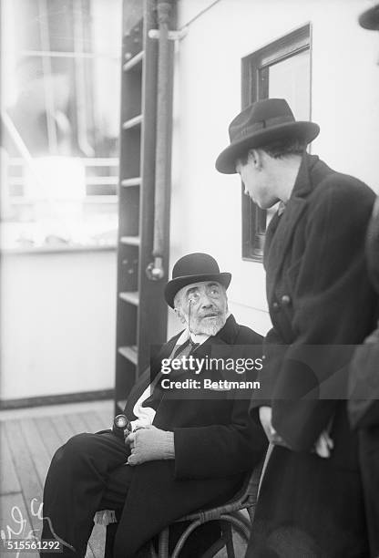 New York, NY- Joseph Conrad, noted author of sea stories and adventure, arrives in New York on the S.S. Tuscania. He is pictured seated on the deck...