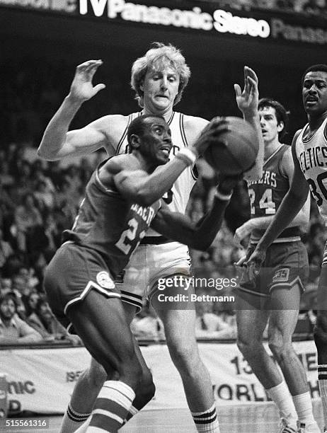 Celtics' Larry Bird towers over 76ers' Andrew Toney who tries to make a shot during third quarter action of game 2 of the Eastern Conference Finals...