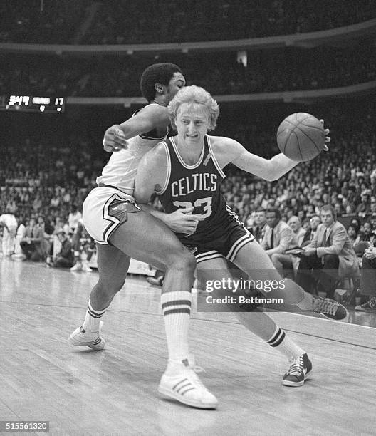 Driving for the basket, Boston Celtics' Larry Bird puts a shoulder into Chicago Bulls, David Greenwood in the first quarter action of the...