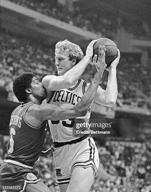 Julius Erving takes Celtics' Larry Bird's shoulder in the face as Bird goes for the basket in 2nd quarter action of the seventh NBA semi-final...