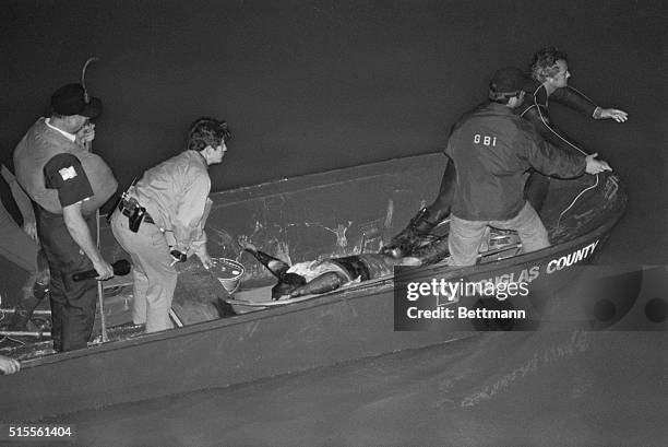 The body of a black teenager lies face up in Douglas County boat moments after it was pulled from the Chattahoochee River near midnight. The body,...