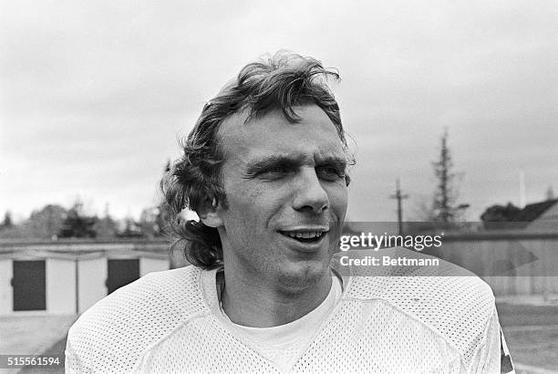 San Francisco 49ers quarterback Joe Montana is shown in a head and shoulders close-up, smiling.