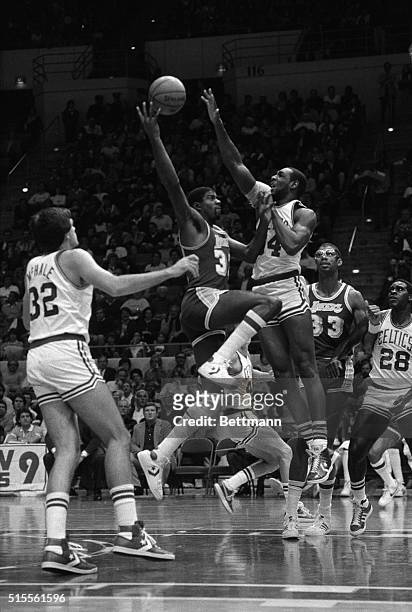 Los Angeles guard Earvin "Magic" Johnson tries over the out-stretched arms of Celtics' forward Winfred King during the first quarter of play of an...