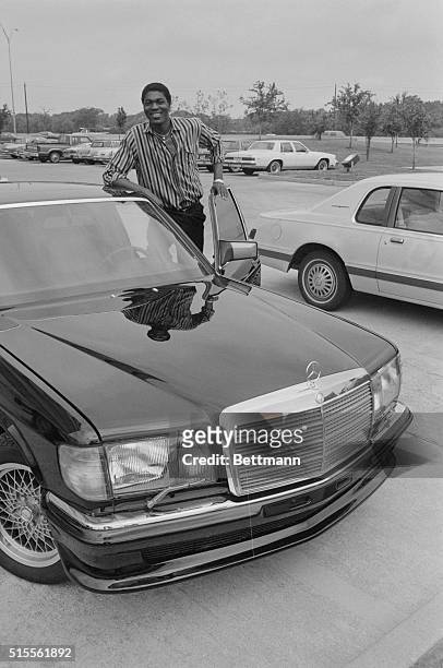 The Houston Rockets won a coin toss in New York which could allow Akeem Olajuwon to play NBA basketball. Akeem stands next to his new Mercedes here,...