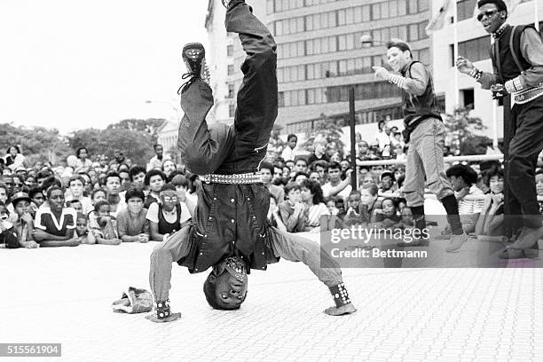 During the First Greater Washington Break Dancing Competition,---a breakdancer has his hands on the floor, while his three teammates stand behind...