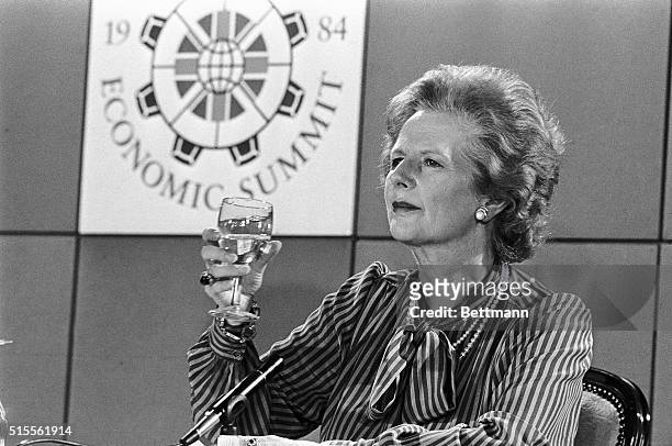 London, England- Prime Minister, Margaret Thatcher, appears to be toasting the European Economic Summit at a Cennaught Rooms press conference. The...