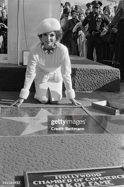 Actress Joan Collins, star of the television series Dynasty, poses for photographers to promote a new perfume by Revlon called Scoundrel at London's...