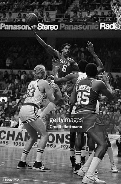 Philadelphia 76ers' Julius Erving goes high over Boston Celtics' Larry Bird and Robert Parish while driving to the hoop in the first quarter of their...