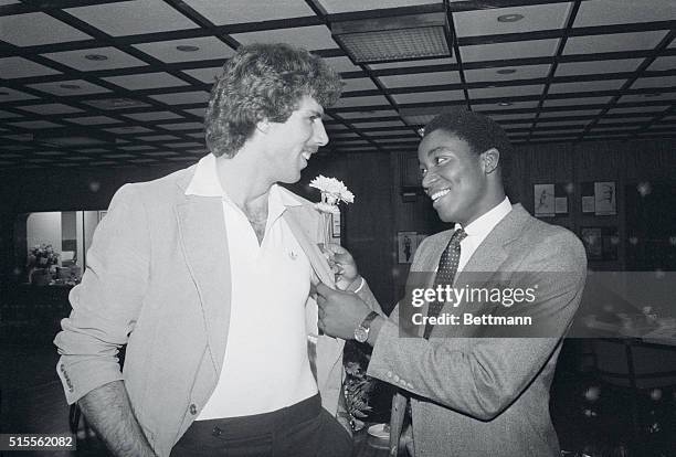 New York: Detroit Pistons' Isaiah Thomas "goofs" on teammate Kelly Tripucka, putting a flower in his lapel during Madison Square garden press...