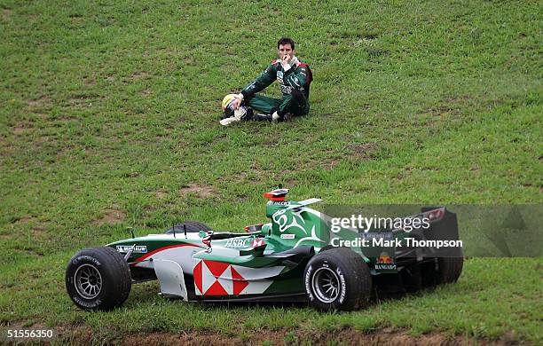 Mark Webber of Australia and Jaguar watches the race after crashing out of the Formula One Brazilian Grand Prix at Interlagos on October 24, 2004 in...