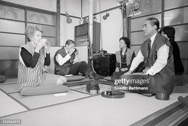 Hinode, Japan: President and Mrs. Reagan drink a cup of tea during a traditional tea ceremony in the country residence of Prime Minister and Mrs....