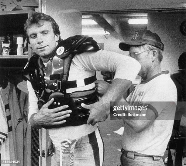 San Francisco 49ers' quarterback Joe Montana is helped on with his newly-designed flak-jacket to protect his injured ribs. Montana sustained rib...