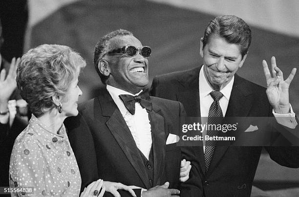 Dallas: A smiling Ray Charles joins President Ronald Reagan and First Lady Nancy Reagan on the podium, taking in the applause after Charles sang...