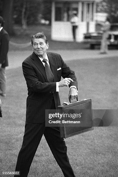 Washington, DC- President Reagan points to his wrist referring to time as he leaves the White House en route to Bowling Green, OH where he will speak...