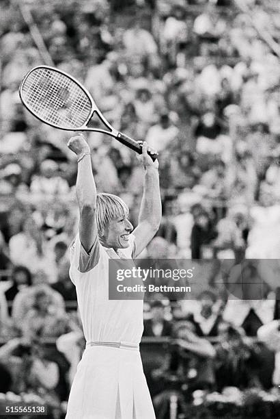 Top seeded Martina Navratilova raises her arms and racket in jubilation as she beats Chris Evert Lloyd 4-6, 6-4, 6-4 to win the Women's Final here at...