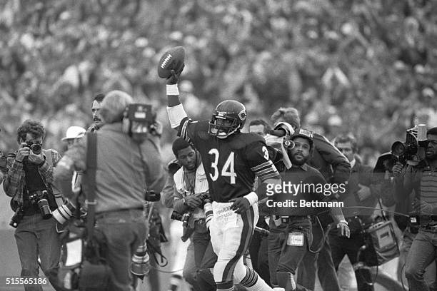 Bears' running back Walter Payton holds aloft the ball after breaking Jim Brown's rushing record in the 3rd quarter of the Saints-Bears game, 10/7.