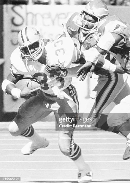 Irving, Tex.: The Dallas Cowboys' Tony Dorsett runs through the grasp of Philadelphia Eagles' Brenard Wilson and Ray Ellis during a first half short...