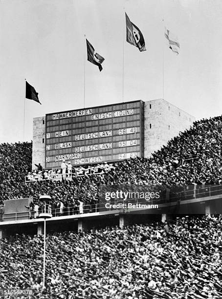 Berlin: German Victory. Arms extend in Nazi salute, as the packed stadium stands to cheer the victory of Hein, and Blask, both of Germany, who...